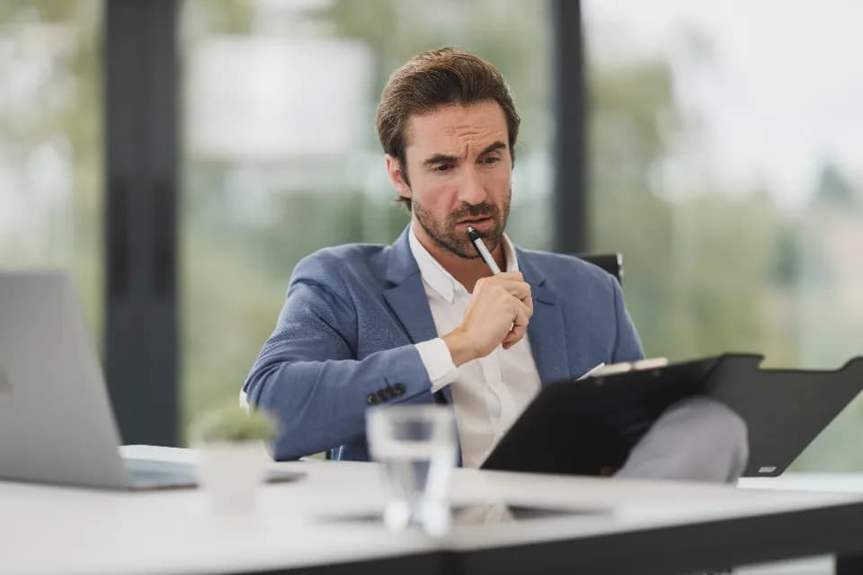 A business professional reviewing documents while evaluating an AI partner